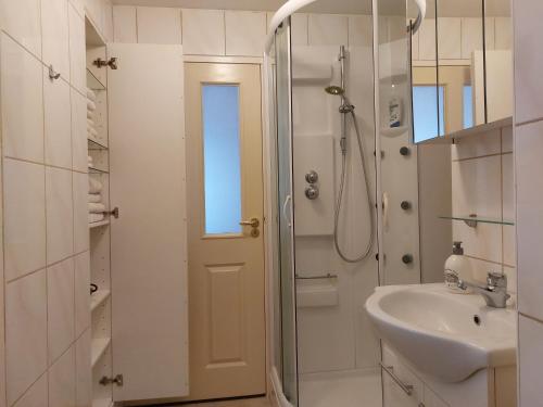 a white bathroom with a shower and a sink at Singelachterhuis Roermond in Roermond