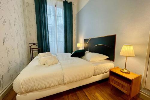 une chambre avec un grand lit blanc avec une fenêtre dans l'établissement Appartement F2, "La Scène du 66", VERDUN CENTRE, Garage motos et vélo, WIFI, Géré par PrestaZen'Services, à Verdun-sur-Meuse