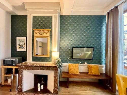 un salon avec une cheminée et un miroir dans l'établissement Appartement F2, "La Scène du 66", VERDUN CENTRE, Garage motos et vélo, WIFI, Géré par PrestaZen'Services, à Verdun-sur-Meuse