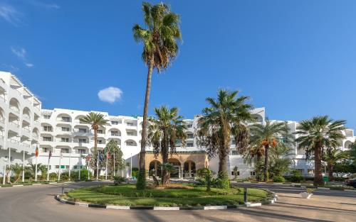 a palm tree in front of a building at Hotel Marhaba Beach in Sousse