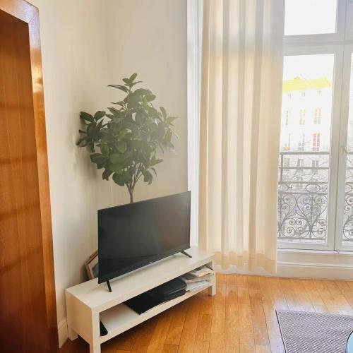 - un salon avec une télévision sur un banc dans l'établissement 2 bedrooms in marais, à Paris