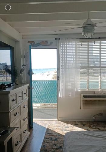 a bedroom with a door leading to the ocean at COUPLES GETAWAY, HONEYMOON SWEET, Perfectly Cozy Beach Front Condo with kitchen, pool, free parking,CHECK-IN AT DOOR in Panama City Beach