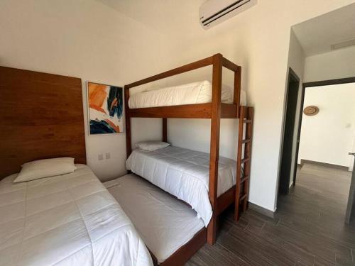a bedroom with two bunk beds in a room at La Mar Monterrico in Monterrico