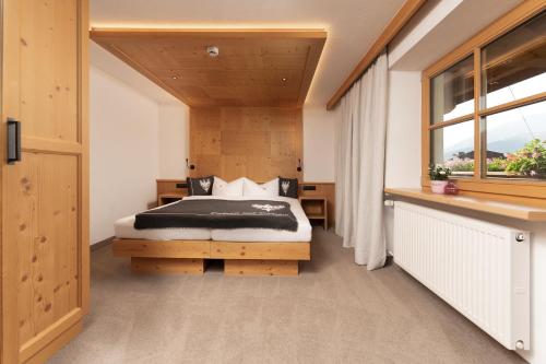 a bedroom with a bed and a window at Berghof Sölden - anno 1588 in Sölden