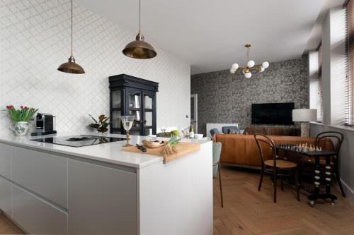 a kitchen and living room with a counter and a table at Cathedral Yard - Art Deco Luxury (Exeter) in Dean