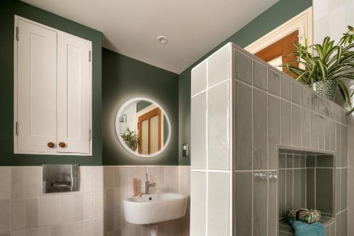 a bathroom with a sink and a mirror at Higher Mapstone - A true retreat nestled in a private sanctuary on Dartmoor in Newton Abbot