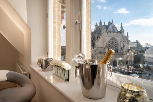 a bottle of champagne in a blender on a window sill at Cathedral View - An Exclusive Private Apartment on Cathedral Green, Exeter in Exeter