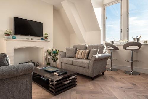 a living room with two chairs and a fireplace at Cathedral View - An Exclusive Private Apartment on Cathedral Green, Exeter in Exeter