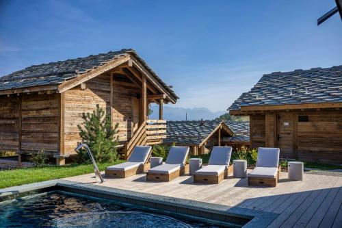 a patio with lounge chairs and a swimming pool at MAD Retreat Hotel in Nendaz