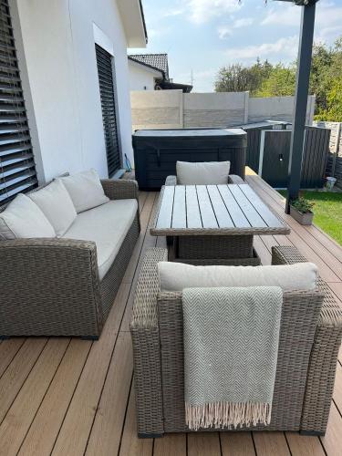 a patio with a table and wicker chairs and a table and a tableearcher at Moderny luxusny domcek s vyhladom na zamok in Prievidza