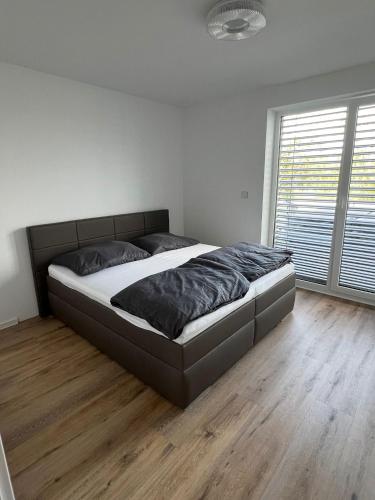 a large bed in a bedroom with a wooden floor at Moderny luxusny domcek s vyhladom na zamok in Prievidza