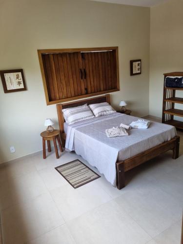 una camera da letto con un letto grande con testiera in legno di Pousada Vida Cunha a Cunha