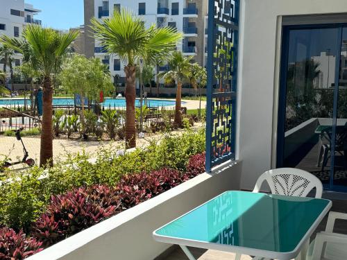 a table on a balcony with a view of a pool at Playa 7 in Martil
