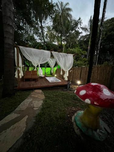 a garden with a red mushroom in the yard at Kombi Cipo Vip - Kombi de Luxo com Hidromassagem in Serra do Cipo