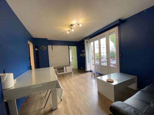 un salon avec une table blanche et un mur bleu dans l'établissement 3chambre 90m2 paking, à Vitry-sur-Seine