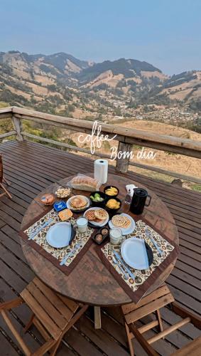 a table with food on top of a deck at Chalé Serra dos tucanos in Gonçalves
