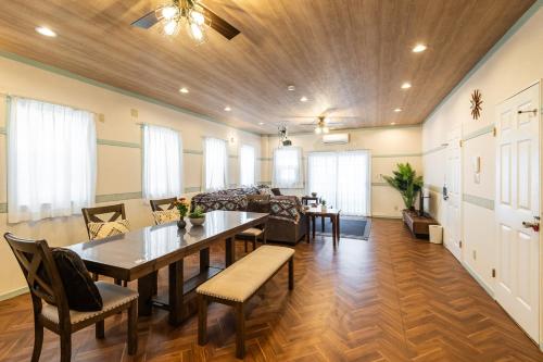 a living room with a table and a couch at ペンション アラナハウス沖縄 in Toya