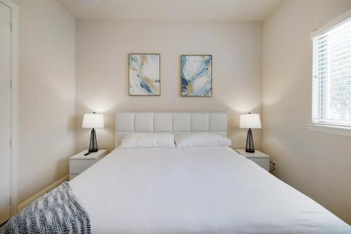 a bedroom with a large white bed and two lamps at Spacious & Luxe 5 Star Neighborhood Movie Theatre in Frisco