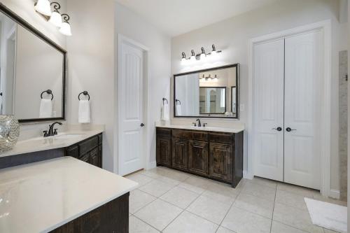 a bathroom with two sinks and a large mirror at Spacious & Luxe 5 Star Neighborhood Movie Theatre in Frisco