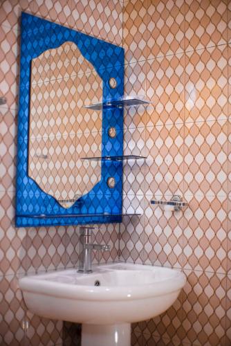 a bathroom with a sink and a mirror at karibu la kossa in Tuvaila