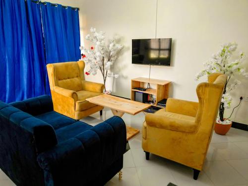 Tuvailaにあるkaribu la kossaのリビングルーム(ソファ、椅子2脚、テレビ付)