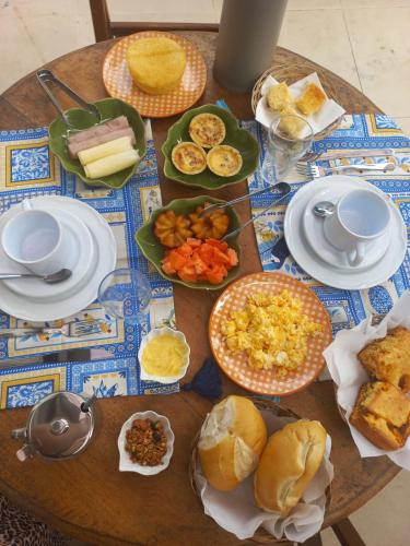 a wooden table with plates of food on it at Vilare Pousada in Morro de São Paulo
