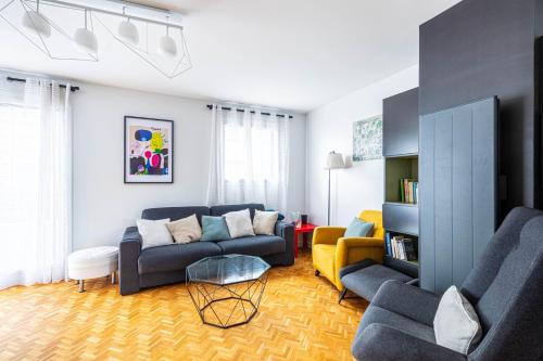 un salon avec un canapé bleu et un fauteuil jaune dans l'établissement GuestReady - Séjour familial dans le 20ème, à Paris