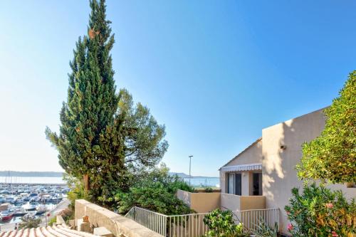 une maison avec deux arbres devant un port dans l'établissement Résidence Pierre & Vacances Bandol Port, à Bandol