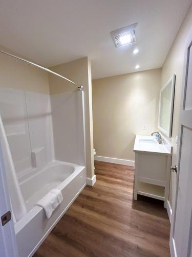 a bathroom with a shower and a tub and a sink at Hotel Pemaquid in Bristol