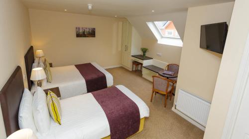 a hotel room with two beds and a flat screen tv at Ashville House in Killarney