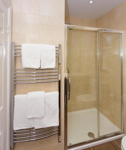 a bathroom with a shower with towels on a towel rack at Ashville House in Killarney