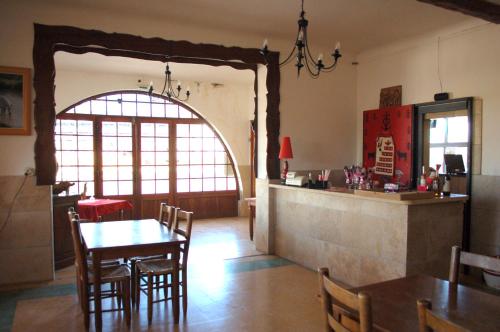 une cuisine et une salle à manger avec une table et des chaises dans l'établissement Hôtel Restaurant l'Agachon, à Albaron