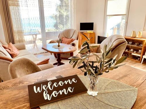 Una sala de estar con un cartel de "Bienvenido a casa" sobre una mesa en Chalet Elli's Mountain View, en Velje Selo