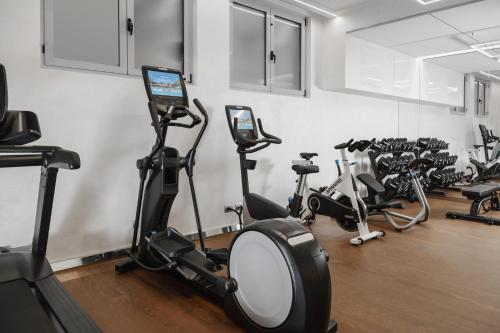 a gym with several treadmills and exercise bikes at Hotel La Maison Wellness & Spa in Alleghe