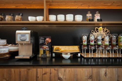 a counter with a bar with food and drinks at Hotel La Maison Wellness & Spa in Alleghe