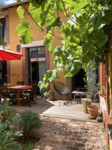 un patio avec une table, des chaises et des plantes dans l'établissement Le 16 maison d'hôtes en Berry, à Henrichemont