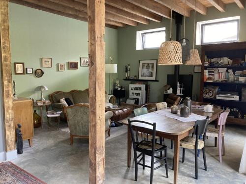 a living room with a table and a couch at Le 16 maison d'hôtes en Berry in Henrichemont