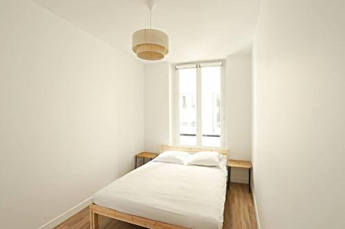 une chambre blanche avec un lit et une fenêtre dans l'établissement Stylish Two-Bedroom Apartment in Saint-Germain, à Paris