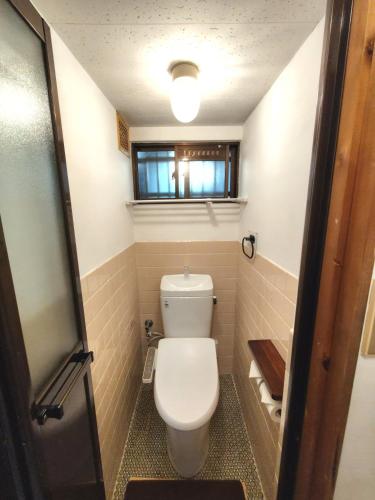a small bathroom with a toilet and a window at Old style japanese house Minpaku Yanoya in Otsu