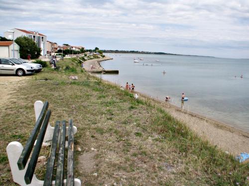 a beach with a group of people swimming in the water at Apartment Vitko in Nin