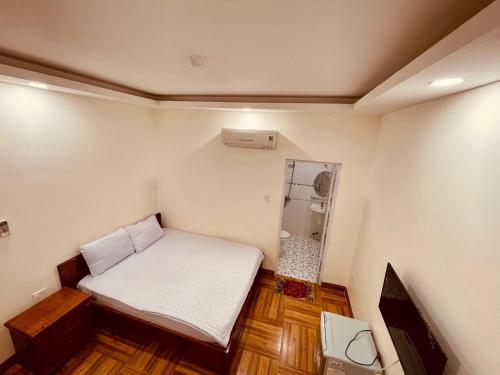 a small room with a bed and a mirror at Sun Sea Hotel in Quy Nhon