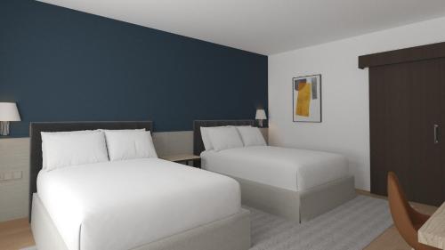 una camera d'albergo con due letti e un divano di Hotel Crowne Plaza Madrid Airport a Madrid
