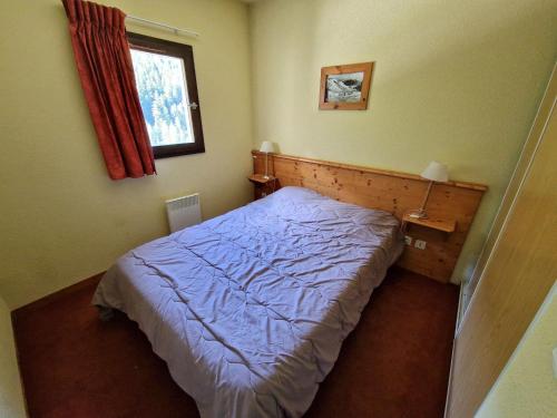 une petite chambre avec un lit et une fenêtre dans l'établissement T2 pour 4 personnes, à 30m des pistes et des commerces, Valfréjus - FR-1-265-207, à Valfréjus