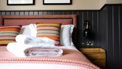 a bedroom with a bed with colorful pillows at The Lawrance Luxury Aparthotel - Harrogate in Harrogate
