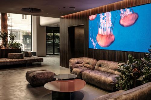 a living room with a couch and a large screen at Fitch Hotel in St Julian's
