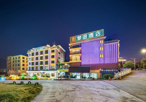 a building is lit up in purple at Zhangjiajie DreamWay Hotel - Free pick up service in Zhangjiajie