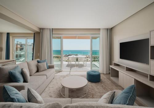 a living room with a couch and a television at Dom Pedro Residences in Vilamoura