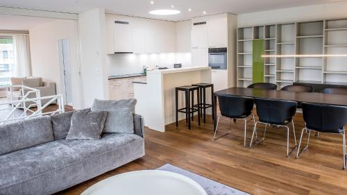 a living room with a couch and a table and a kitchen at City Apartments in Zug
