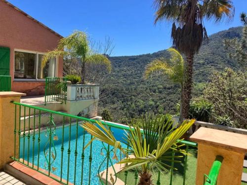 une maison avec une piscine et un palmier dans l'établissement Maison conviviale à Fréjus avec piscine à débordement, à Fréjus
