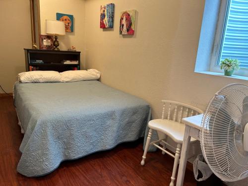 a bedroom with a bed and a fan and a chair at Iowa Nice, Winterset in Winterset